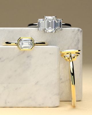 Emerald three stone in platinum, emerald east west bezel in yellow gold, round bezel in yellow gold