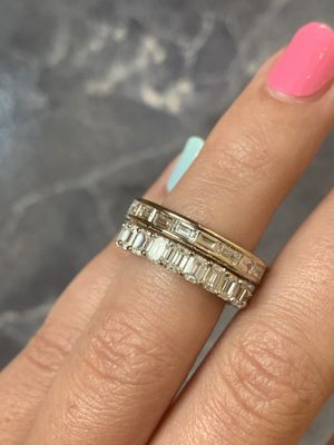 custom baguette channel band paired with emerald eternity band in yellow gold