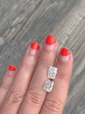 two radiant cut lab grown diamonds on a hand