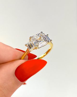 Asscher three stone with trapezoid sidestones set in yellow gold